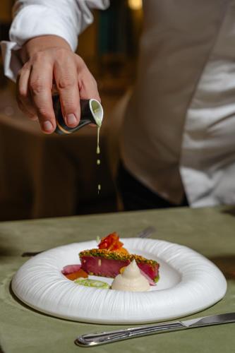 a person eating a piece of cake on a plate at SunGarden Golf & Spa Resort in Cluj-Napoca