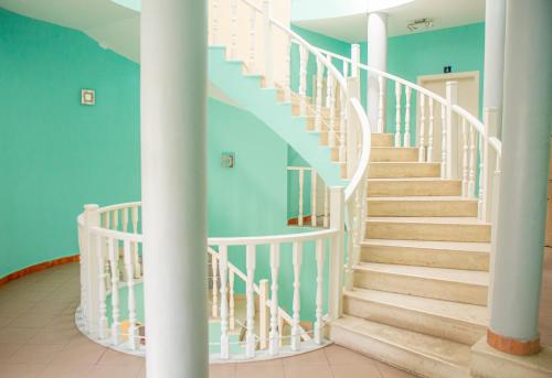 una escalera en una casa con paredes azules y barandillas blancas en The Golden Rooster, en Tirana