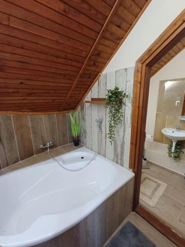 a bathroom with a white tub and a sink at Vozi Rooms in Méhkerék