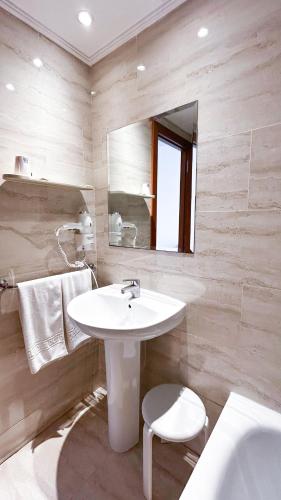 a white bathroom with a sink and a mirror at Hotel Primavera Benidorm in Benidorm