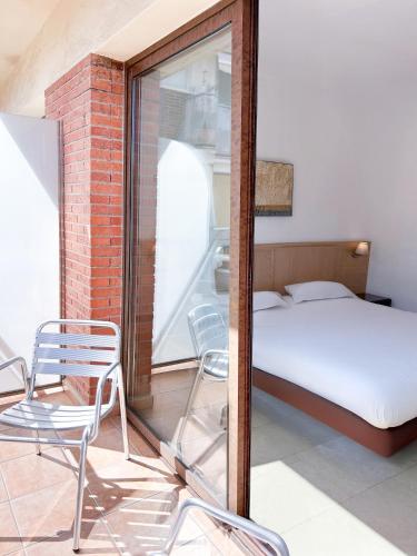 a bedroom with a bed and a chair and a mirror at Hotel Primavera Benidorm in Benidorm