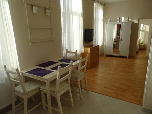 a dining room with a table and chairs and a refrigerator at Alabárdos Panzió és Apartmanház in Esztergom