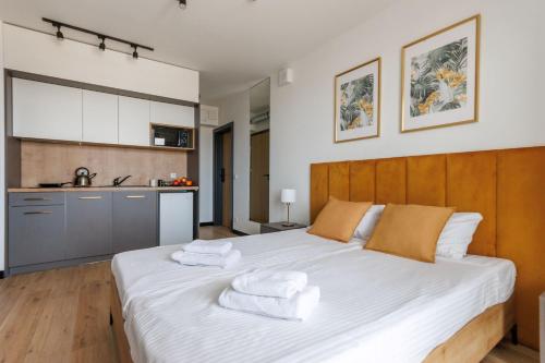a bedroom with a large white bed with towels on it at Zeus Apartments Lublin in Lublin