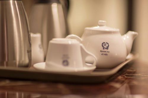 a table with a tea pot and cups on a plate at رؤوم ان للشقق الفندقية- Raoum Inn Hotel Apartments-Sakaka in Sakakah