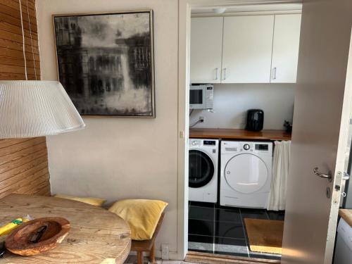 a kitchen with a table and a washing machine at Villa Helt - Helts Guesthouse in Herning
