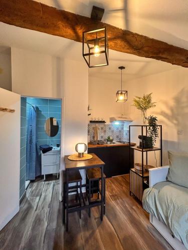 Cette chambre comprend un lit, une table et une cuisine. dans l'établissement La Petite Escale Studio de 16m2, à Montauban