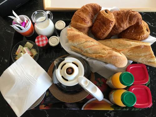 a tray with bread and croissants and a cup of coffee at Chez Doukine, Appartement avec balcon à Chouzelot in Chouzelot