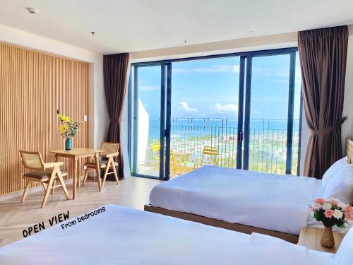a hotel room with two beds and a table with a view at Luxury SeaView Apartment in 5 star Resort, An Bàng - Hội An in Dien Ban