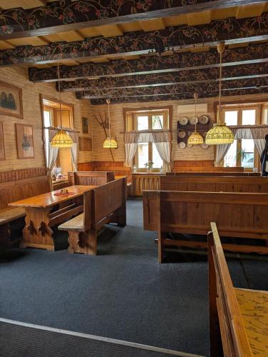 a large room with wooden tables and benches at Pension Harcovna in Frýdlant nad Ostravicí