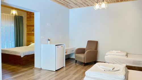 a room with two beds and a desk and a chair at Jasmin Pansiyon Çıralı in Cıralı
