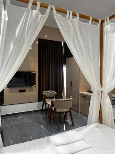 a bedroom with a bed and a table and chairs at Hotel The Octave in Surat