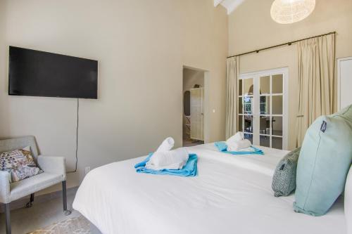 a bedroom with a white bed with towels on it at Villa Toucan Curacao in Jan Thiel