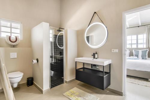 a bathroom with a sink and a shower and a toilet at Villa Toucan Curacao in Jan Thiel