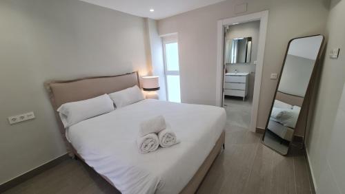 une chambre avec un lit blanc avec deux serviettes dessus dans l'établissement Navas PentHouse 301 By Florentia Homes, à Grenade