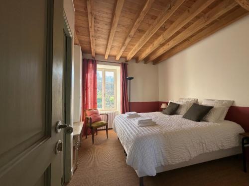 une chambre avec un lit et une fenêtre dans l'établissement La Petite Montjoie - Maison vigneronne, à Tharoiseau