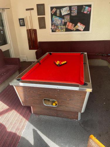a pool table with a red cover in a room at The Aberford in Blackpool