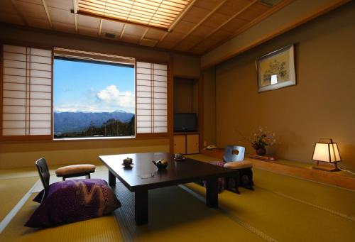 a living room with a table and a window at Futari Shizuka in Komagane