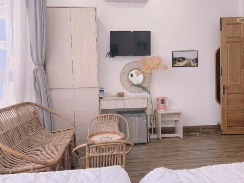 トゥイホアにあるThành Tính Hotel - Khách sạn Phú Yênの椅子2脚とテレビのあるリビングルーム
