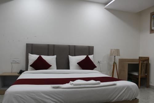 a bedroom with a large bed with red and white pillows at Castle Grand Dwarka in New Delhi