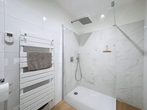 une salle de bain blanche avec douche et toilettes dans l'établissement T2 moderne en rez-de-villa, à Calvi