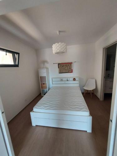 une chambre avec un lit blanc dans une pièce dans l'établissement T2 moderne en rez-de-villa, à Calvi