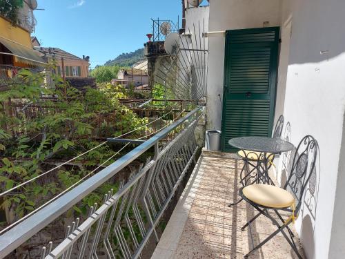 a balcony with a table and chairs and a green door at SUITE-appartamento-del B&B dei DORIA in Dolceacqua