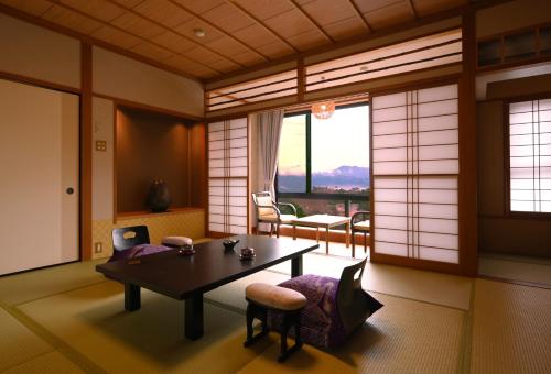 a room with a table and chairs and a window at Futari Shizuka in Komagane