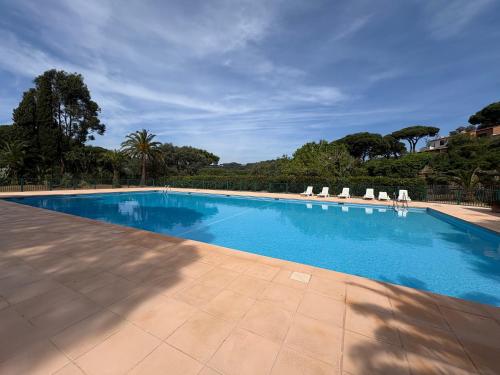 une grande piscine avec des chaises longues et des arbres dans l'établissement Mas à la Plage- 2 bedrooms, Terrace, Parking, à La Croix-Valmer