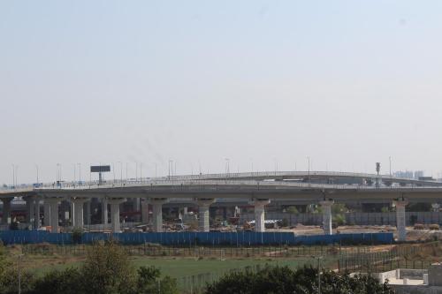 a bridge over a construction site with a road at Castle Grand Dwarka in New Delhi