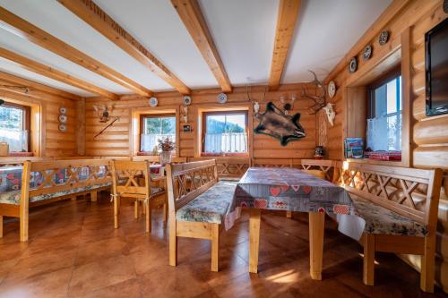 a dining room with wooden walls and a table and chairs at Chata Šafran in Liptovský Ján