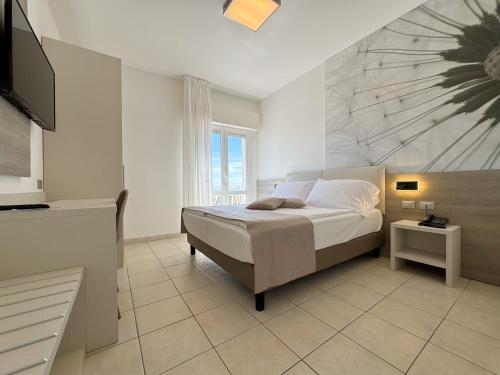 a bedroom with a bed and a television in it at Hotel Lux in Caorle