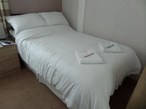 a white bed with two towels on top of it at Nathans in Blackpool