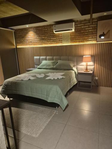 a bedroom with a bed with a green comforter at LOFT COSTANERA 200mts in Encarnación