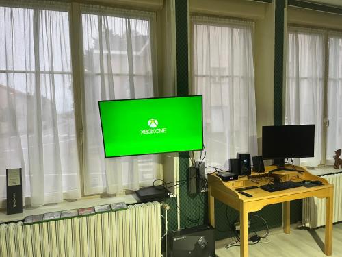 a tv with a green screen in a room with windows at Deux chambres Terrasse salle de sport in Vigneulles-lès-Hattonchâtel