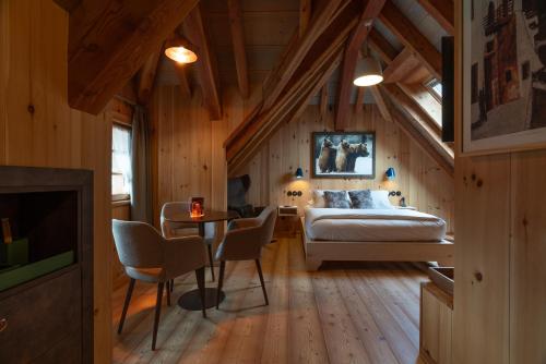 a bedroom with a bed and a table and chairs at Hammerack Hotel, SPA & Wellness in Malborghetto Valbruna