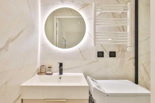 une salle de bain blanche avec un lavabo et un miroir dans l'établissement Newly renovated appartement ☆ Canal de L'ourq ☆, à Paris