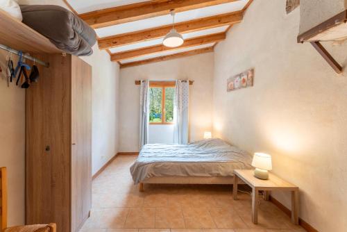 a bedroom with a bed and a table in a room at La Petite Palasse in Le Thor