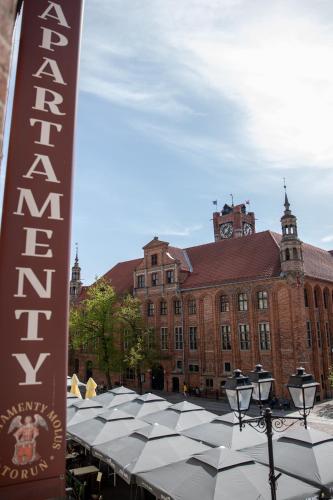 a large building with a sign in front of it at Apartamenty Molus na Rynku Staromiejskim in Toruń