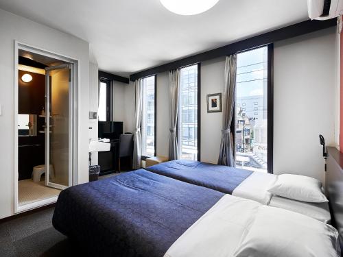 Postel nebo postele na pokoji v ubytování 井筒ホテル 京都河原町三条