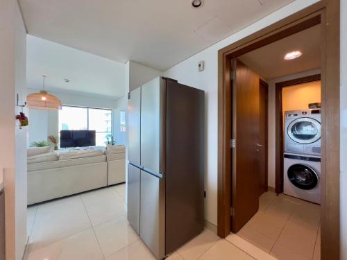a kitchen and living room with a washer and dryer at Modern 3 Bedroom Al Hadeel West Side Al Rahah Beach in Abu Dhabi