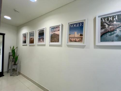 a row of pictures on a wall in a gallery at Modern 3 Bedroom Al Hadeel West Side Al Rahah Beach in Abu Dhabi