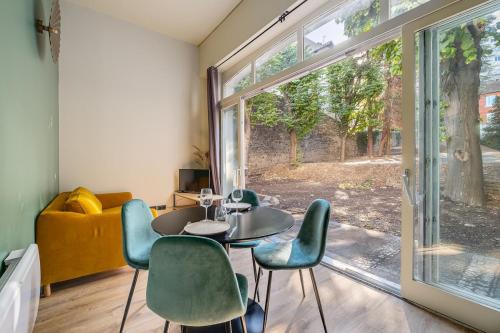 une pièce avec une table, des chaises et une fenêtre dans l'établissement Appartement avec terrasse spacieuse, Saint-Étienne, à Saint-Étienne
