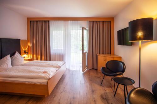 a hotel room with a bed and a chair at Springbach-Mühle Belzig in Bad Belzig
