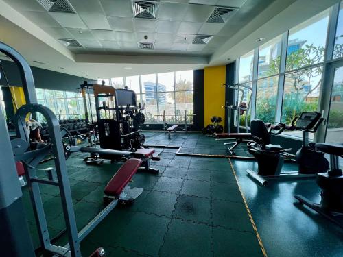 a gym with lots of tread machines and windows at Modern 3 Bedroom Al Hadeel West Side Al Rahah Beach in Abu Dhabi