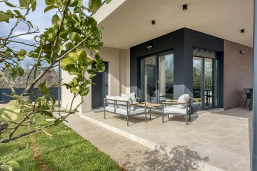 un patio con due sedie e un tavolo di Villa Gigi - Happy Rentals a Višnjan (Visignano)