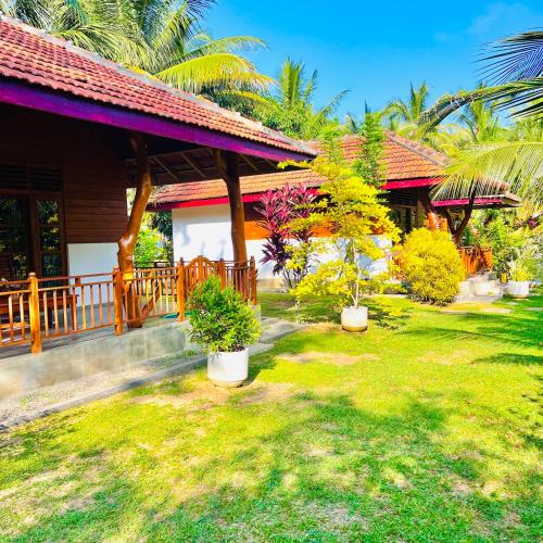 a house with a yard with potted plants in it at Hanguk Lanka Lagoon Villa in Tangalle