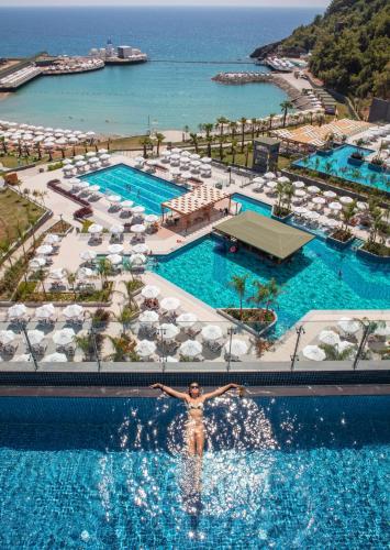 a man swimming in a pool at a resort at Mylome Luxury Hotel & Resort - Ultra All Inclusive in Okurcalar