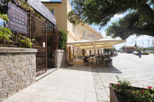 a restaurant with tables and umbrellas on a street at Kemani Villa Sara - Boutique Guest House in Olbia