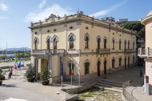 a large building with flags in front of it at Kemani Villa Sara - Boutique Guest House in Olbia