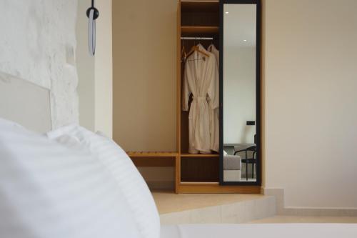 a bedroom with a closet with a robe at Pnoe Villas Syros in Megas Yialos-Nites
